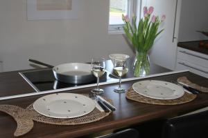a table with two plates and glasses of wine at Juli-Huus in Bastorf