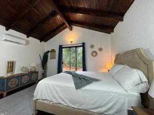 皮里韦维AltaVista Lodges的一间卧室，里面有一张白色床，窗外是一扇窗户。