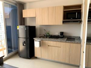 a kitchen with a stainless steel refrigerator and cabinets at Exclusive Apartasuite El Encanto in Santa Marta