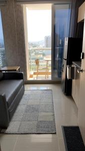 a living room with a couch and a large window at Exclusive Apartasuite El Encanto in Santa Marta