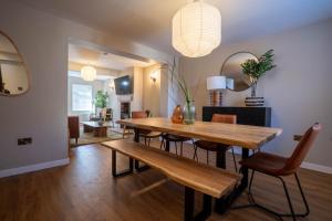 a dining room with a wooden table and chairs at Church Road Retreats - Driftwood in Kessingland