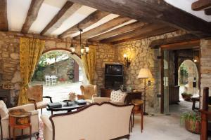 a living room filled with furniture and a stone wall at Posada La Torre de La Quintana in Liendo