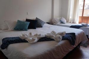 twee bedden met bloemen in een kamer bij Hermoso Apartamento Faros de la Villa a 4 calles de la Plaza in Villa de Leyva