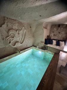 a swimming pool in a building with a dragon on the wall at Wish Cappadocia Love in Uçhisar