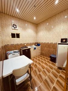 Una cocina con una mesa y sillas en una habitación. en عروس الشاطئ للشقق المخدومة, en Umm Lajj