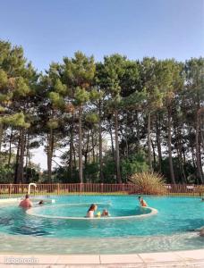 a group of people swimming in a swimming pool at T2 32m2 terrasse 8m2 PISCINE LACANAU OCEAN LAC GOLF MULTISPORT in Lacanau +30 photos