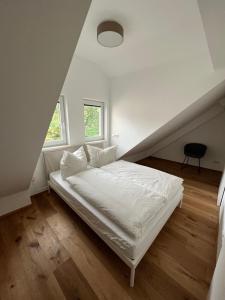 a white bed in a room with two windows at Ferienhaus Domblick Merseburg in Merseburg