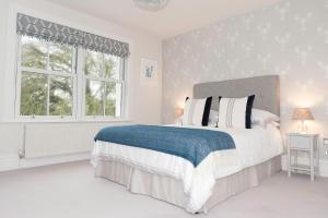 a white bedroom with a large bed and a window at Ultimate Coastal Luxury - 5 Bed, Spacious, Parking, Hot Tub in Malborough +67 photos