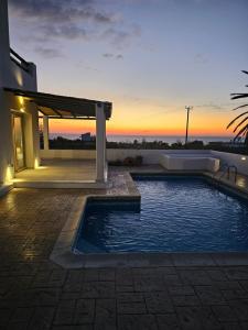 a house with a swimming pool and a sunset at Villa Enalia Paphos in Paphos City +59 photos
