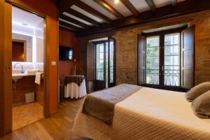 a bedroom with a bed and a bathroom with a sink at PR Badalada in Santiago de Compostela