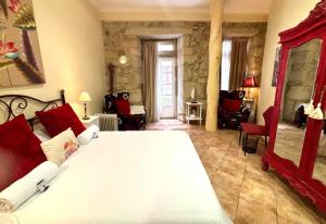 1 dormitorio con 1 cama blanca grande y muebles de color rojo en Holibai, Vermello, Un rincón con encanto cerca de la playa, en Baiona