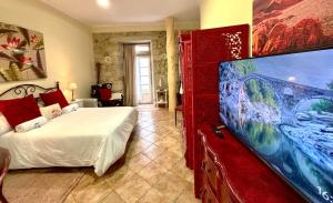 Un dormitorio con una cama y un televisor de pantalla plana. en Holibai, Vermello, Un rincón con encanto cerca de la playa, en Baiona
