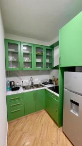 a green kitchen with a sink and a refrigerator at Adriatic Bliss in Golem beach in Golem