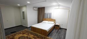 a small bedroom with a bed and a rug at EveResT in Osh