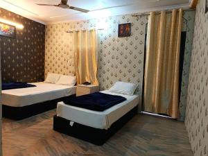 une chambre avec deux lits et une fenêtre dans l'établissement Haveli Heritage --- 200 Meters from Nizamuddin Railway Station, à New Delhi