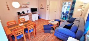 Una sala de estar con un sofá azul y una mesa. en Fewo 91 WHG A 8 in Burhave, en Burhave