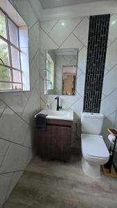 a bathroom with a toilet and a sink and a mirror at Lavender Lofts in Centurion