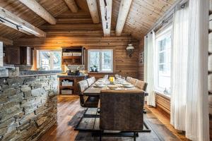 a dining room with a table and a stone wall at Vacation house in Hemsedal in Hemsedal
