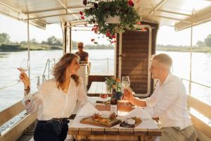 a man and woman sitting at a table with wine glasses at Winny Dworek in Sulechów