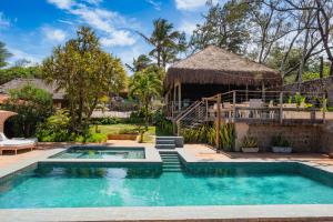 a swimming pool in front of a house at Hotel da Pipa in Pipa