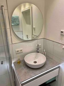 a bathroom with a sink and a mirror at Ferienwohnung Herzmuschel in Varel +19 photos