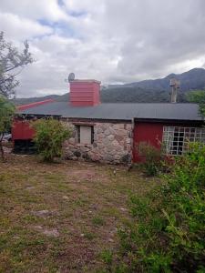 a house with a red roof and a stone building at Casa Chakana in La Cumbre