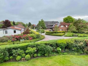 a garden with bushes and flowers in a residential neighborhood at Ferienwohnung Herzmuschel in Varel