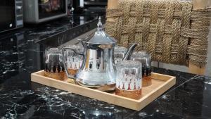 a tray with a tea kettle and glasses on a counter at Appartement lux dakhla in Dakhla