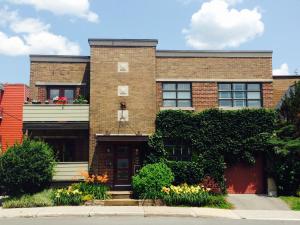 a brick building with flowers in front of it at L'Adresse Botanique - Studio in Montréal