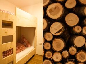 a room with a bunk bed and a pile of logs at Preindlerhof Farmhouse in Santa Maddalena