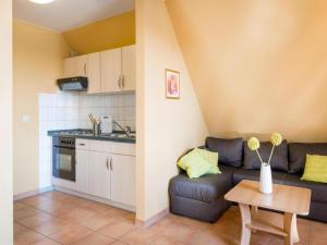 a kitchen and a living room with a couch and a table at Ferienwohnung auf dem Fischerhof, Vipperow in Vipperow