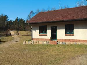 a house with two windows and a stone fence at Ferienwohnung, Lohmen in Lohmen