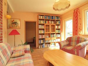 a living room with two chairs and a table and bookcases at Ferienwohnung, Lohmen in Lohmen +4 photos