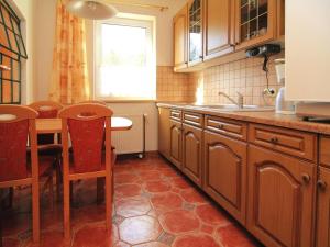 a kitchen with wooden cabinets and a table and a sink at Ferienwohnung, Lohmen in Lohmen