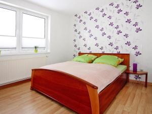Un dormitorio con una gran cama de madera con almohadas verdes en Ferienwohnung, Ribnitz-Damgarten, en Ribnitz-Damgarten