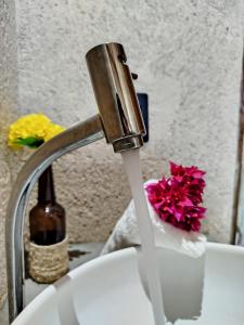 a sink with water coming out of a faucet at Casa Areia Bela - Patacho in Pôrto de Pedras
