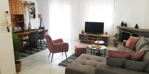 a living room with a couch and chairs and a television at Family Spacious Apartment Veria in Veria