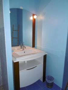 een badkamer met een witte wastafel en een spiegel bij Au petit lieu-dit in Anglade