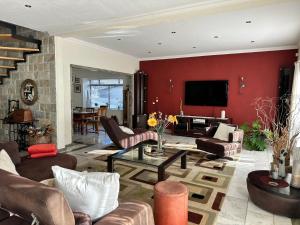 a living room with red walls and leather furniture at The Beach Residence in Swakopmund +21 photos