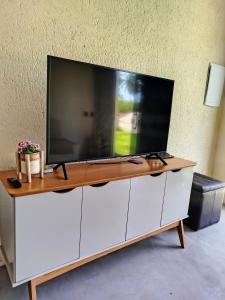 a large tv on top of a white cabinet at Casa Areia Bela - Patacho in Pôrto de Pedras +14 photos