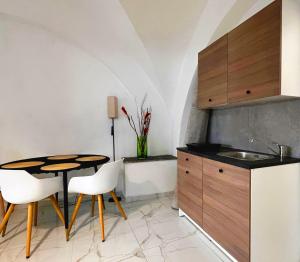 a kitchen with a sink and a table and chairs at Il Tarquiniese in Tarquinia