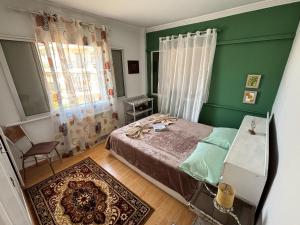 a bedroom with a bed and a green wall at Nirvana Apartment Quiet Stay with Free Parking & Airport Access in Athens