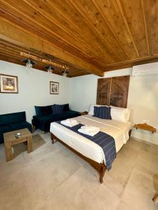 a bedroom with a large bed and a couch at Midgard Suites (Medieval Town) in Rhodes Town +18 photos