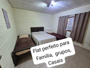 a small room with a bed and a sign on it at Flat na área central de Valadares Com AR garagem wifi cozinha completa para grupos ou casais in Governador Valadares