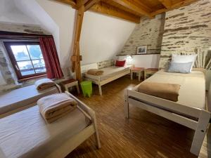 a bedroom with two beds and a couch in a room at Gîte et Hostel Le Ty Bihui in Bieuzy-les Eaux