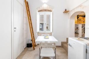 a small kitchen with a white table and chairs at Le Bianche Suites Ostuni in Ostuni +88 photos