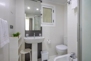 a white bathroom with a sink and a toilet at Apartamentos Senabre Palais in Benidorm +63 photos