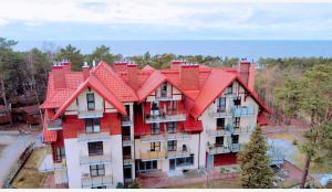 an apartment building with a red roof at Bulwar17 in Krynica Morska