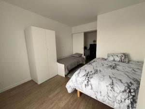 Un dormitorio con dos camas en una habitación. en L'aile du Moulin, en Magny-le-Hongre