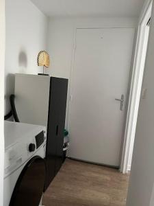 una habitación con una puerta blanca y un aparato blanco en L'aile du Moulin, en Magny-le-Hongre